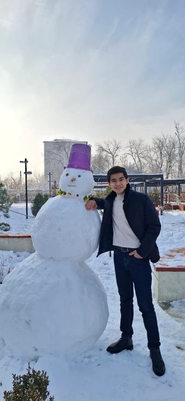 Abdulhamid beside a snowman