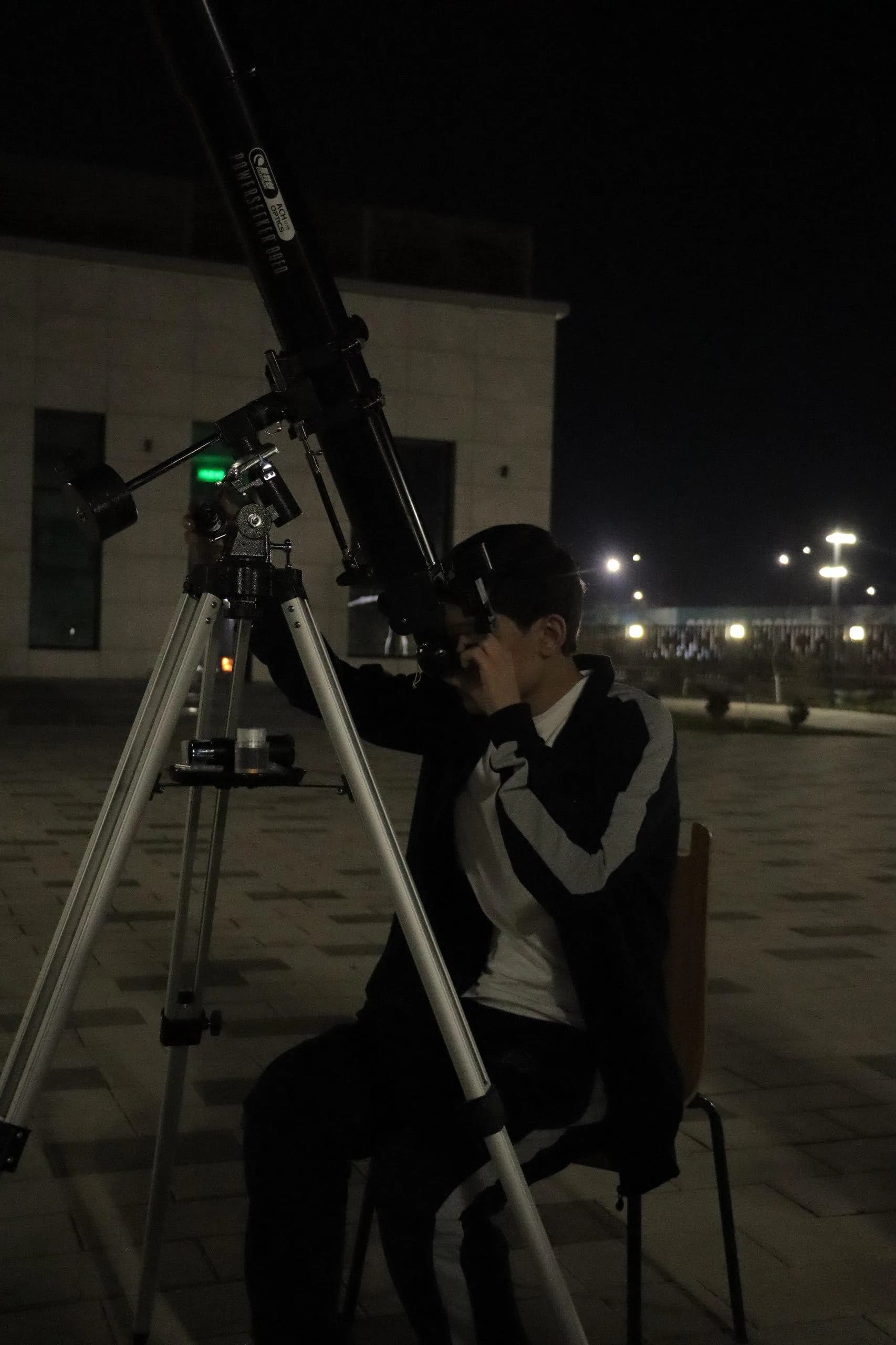 Abdulhamid looking through a telescope at night